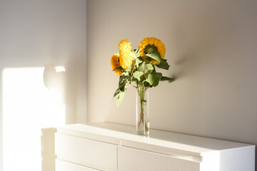 Yellow sunflowers in white room. Soft selective focus.