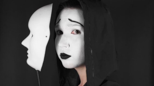 Portrait of a mime and bodypainting woman in white with black lips. Mime woman on black background. 
