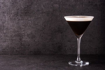 Martini espresso cocktail in glass on black background. Copy space