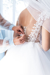 Obraz na płótnie Canvas fasten the bride's dress