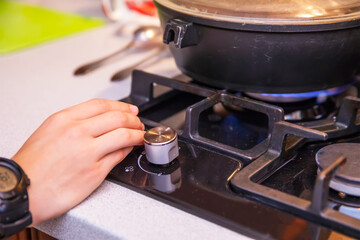 A man sets fire to the comfort of a gas stove with a frying pan. Cooking.