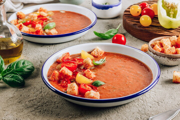 Spanish summer cold soup gazpacho with vegetables on concrete background.