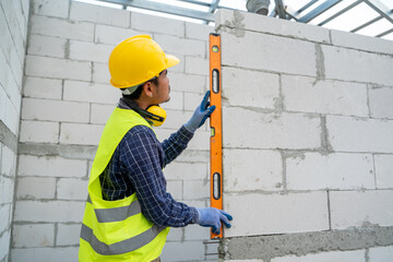 Technician with Laser measurement level for work at construction site.