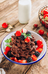 Chocolate waffles with milk and berries for breakfast on rustic wooden background. Chocolate cookies amerikaner shaped waffles. Selective focus