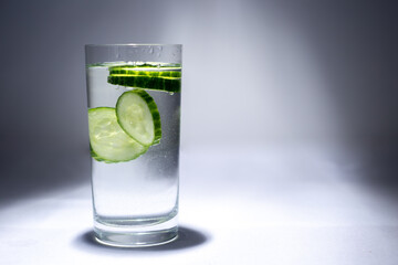 Glass cup with water and cucumber slices
