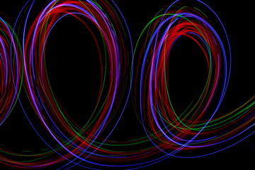 Long exposure photograph of neon multi colour in an abstract swirl, parallel lines pattern against...