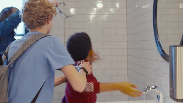 Boys putting off african pupil glasses and bullying him in school restroom