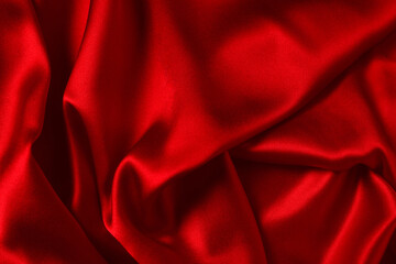Red silk or satin luxury fabric texture can use as abstract background. Top view.