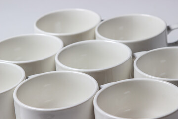 White cups on a white background. Lots of empty tea cups.
