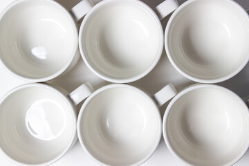 White cups on a white background. Lots of empty tea cups.