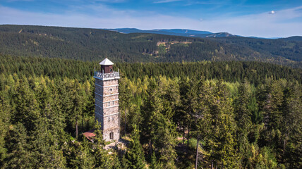 Pajndl, Czech republic - aerial view of old stone observation tower in Ore mountains, CZ: Krusne hory. Panoramic drone view of mountain range, forest and beautiful historical building in nature.