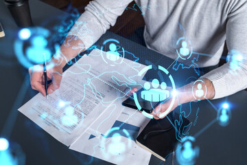 Double exposure of man signing contract with phone and social network icon hologram. Concept of international business of data and information.