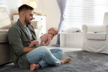 Obraz premium Father with his newborn son at home