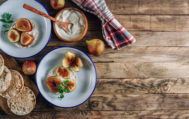 Healthy snack wholegrain rice crispbread crackers, figs and ricotta cheese on rustic wooden background. Top view
