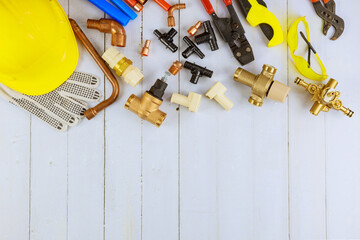 Plumbing tools, pipe fittings on a home improvement plumbing materials including copper pipe, elbow joint, wrench and spanner.