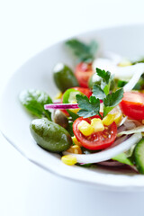 Healthy Salad with Green Olives, Baby Spinach, Cucumber, Cherry Tomatoes and Capers. Bright background. Close up.	