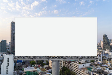 Blank white road billboard with Bangkok cityscape background at sunset. Street advertising poster, mock up, 3D rendering. Front view. The concept of marketing communication to promote or sell idea.