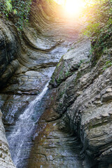 Water flowing or falling down stop motion in the waterfall. vertical photo