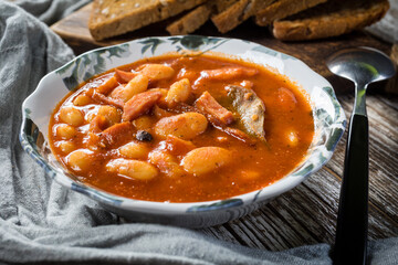 Beans with tomato sauce, bacon and sausage.