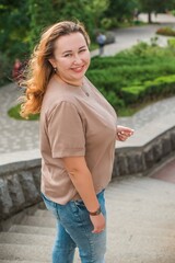 Fototapeta premium Happy smiling beautiful plus size model . Portrait large girl smiling on a sunny day with good mood, Photo of new age standard of beauty