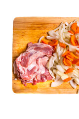 Pork meat cut into pieces with carrots and onions on a cutting Board on a white background with a place for writing,side view