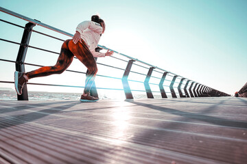 outdoor workout concept. young woman in tracksuit performs sports workout on the pier