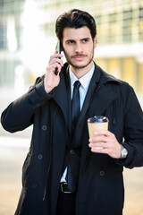 Young manager on the phone outdoor in an urban setting