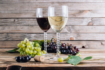 Glasses of red and white wine with grape on rustic wooden background. Selective focus