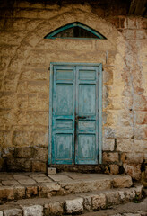 old blue wooden door in the arched stone wall