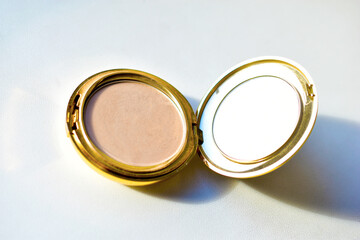 Gold round compact with mirror on white background