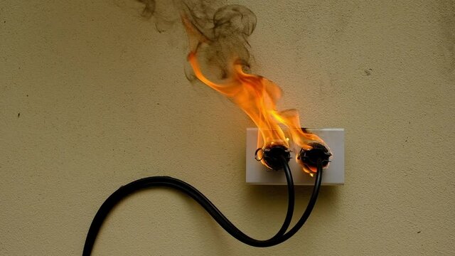 On fire electric wire plug Receptacle on the concrete wall background