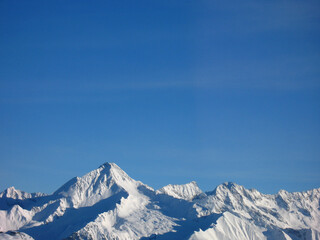 Fototapeta na wymiar Blauer Himmel und schneebedeckte Berggipfel als Hintergrund