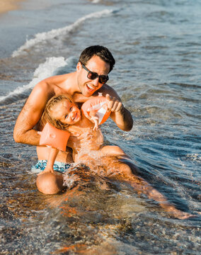 Father and daughter having fun on beach
