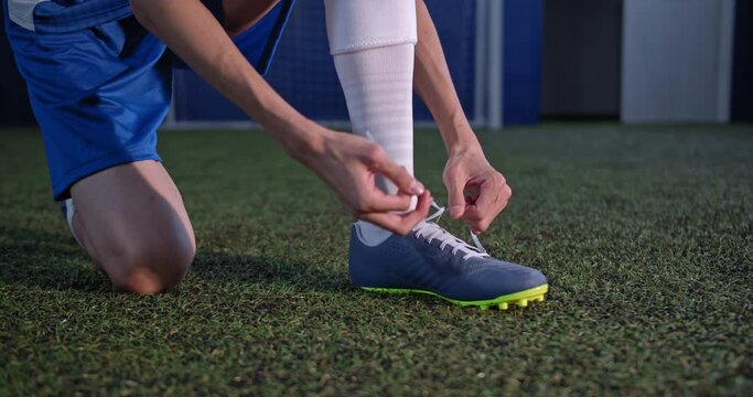 Football player tying his shoe lace preparing for the game
