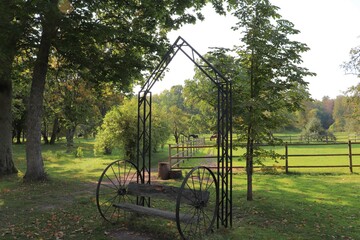 Abstract bench on two large metal wheels next to a horse paddock in Latvia Autumn 2020