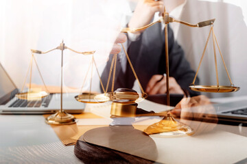 Business and lawyers discussing contract papers with brass scale on desk in office. Law, legal services, advice, justice and law concept picture with film grain effect