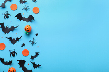 Halloween decor elements on light blue background, flat lay. Space for text