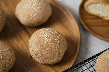 Fototapeta na wymiar Gluten free Keto bread. Homemade ketogenic buns with sesame seeds. set on white cafe table.