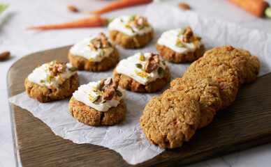 Keto Carrot oatmeal cookies. Healthy homemade ketogenic diet dessert decorated with white cream, nut and seeds. set on white cafe table background.