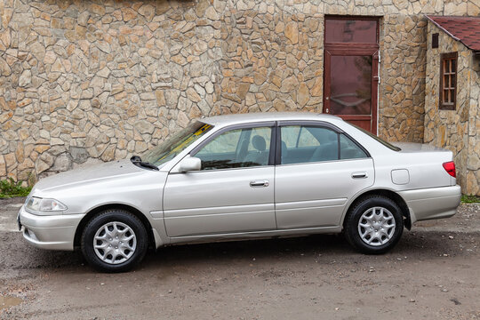 Side view of a Japanese-made car Toyota Carina 2000 year release in gray. Toyota car catalog.