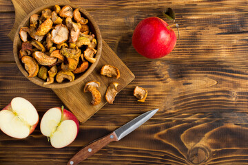Dried apples in the bowl on the brown wooden  background with copy space