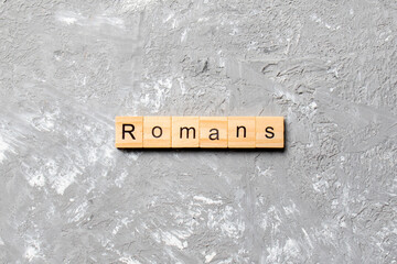romans word written on wood block. romans text on table, concept