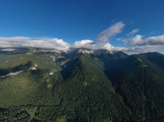 Panorama of beautiful countryside of Italy. Idyllic landscape in the Alps. Clouds on top of the Alps, blue sky. High mountains in the Europe.