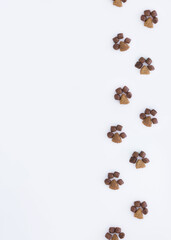 One side frame on the left is made of dry cat food in the shape of paws on a white background.flat...