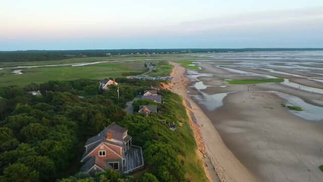 Cape Cod Bay Aerial Drone Footage of Bay Side Beach at Low Tide with Sand Dunes, Marsh and People Walking in Ocean During Golden Hour