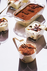 Tiramisu in different shape, various form of serving tiramisu, on glasses, classic, and as a round cake,