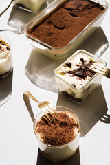 Tiramisu in different shape, various form of serving tiramisu, on glasses, classic, and as a round cake,