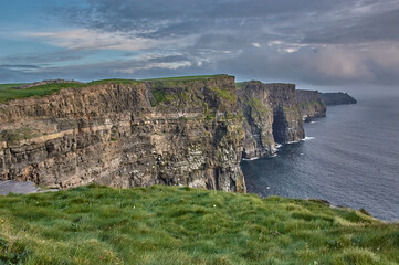 Panoramic view of the Cliffs of Moher, Ireland. Cliffs of Moher during sunset. Coastline in Ireland with huge cliffs.