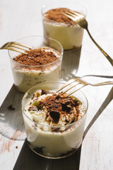 Tiramisu in different shape, various form of serving tiramisu, on glasses, classic, and as a round cake,
