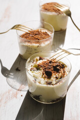 Tiramisu in different shape, various form of serving tiramisu, on glasses, classic, and as a round cake,